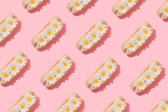 Spring creative pattern with white flowers in hot dog bun pastel pink background. 80s or 90s retro fashion aesthetic bloom concept. Minimal romantic food idea.