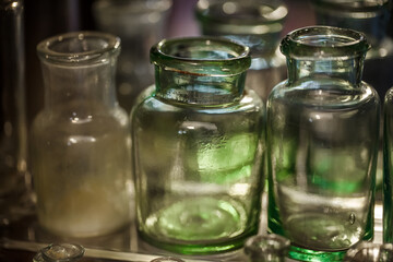 Fototapeta na wymiar Pharmacy flasks old, antique medical glass containers bottles for medicines, selective focus.