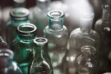 Pharmacy flasks old empty, antique medical glass multi colored, containers, bottles for medicines, selective focus.