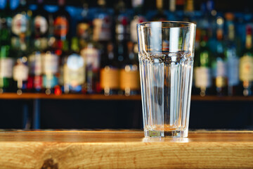 Empty beer glass on a wooden bar counter