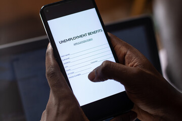black person filling unemployment benefit form on a phone