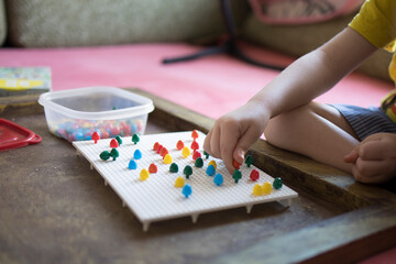 A child of 4 years old collects a puzzle for the development of fine motor skills