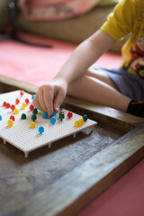 A child of 4 years old collects a puzzle for the development of fine motor skills