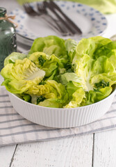 Salad bowl with green lettuce on a dinner table