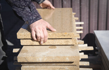 Construction worker holding tile for house building.