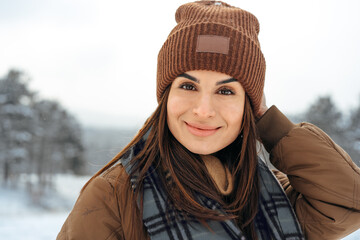 Woman in winter warm jacket walking in snowy winter forest