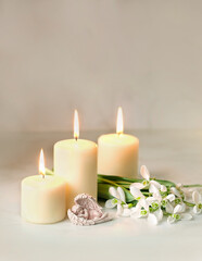 Cute sleeping angel, snowdrops flowers and candles on table, blurred  abstract background....