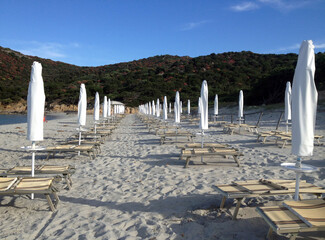 Continuity. Sombrillas y tumbonas en playa desierta.