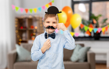 birthday, celebration and childhood concept - portrait of little boy with bowler hat and moustache...