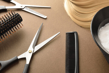 Hairdressing tools for cutting and dyeing hair on brown background