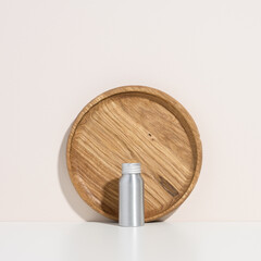 empty silver metal bottle for cosmetics on white table. Packaging for cream, gel, serum, advertising and product promotion