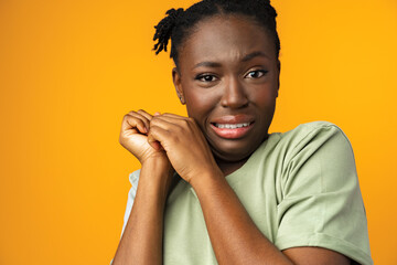 African American beautiful young female has frightened expression as notices something terrible