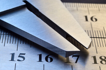 locksmith measuring tool lies on the background of metal rulers. close-up