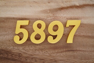 Golden Arabic numerals on a real brown and white wooden floor number 5897