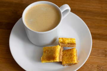A cup of espresso coffee and orange cookies are on the table. Food photo.