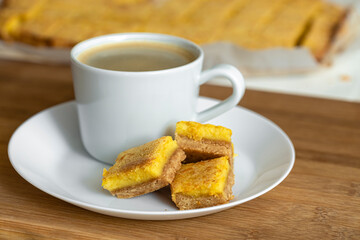 A cup of espresso coffee and orange cookies are on the table. Food photo.