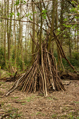 Playhouse made of twigs and sticks in a forest. Adventure hut in nature, day time, no people