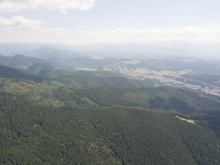 Green mountains of Ukrainian Carpathians in summer. Sunny day, rare clouds. Aerial drone view.