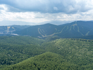 Green mountains of Ukrainian Carpathians in summer. Sunny day, rare clouds. Aerial drone view.