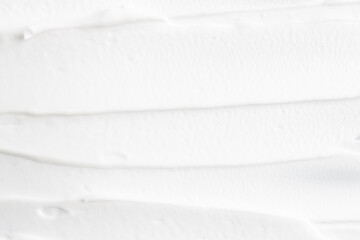 Obraz premium White cosmetic foam applied with brush strokes, top view.