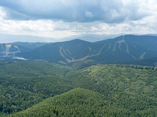 Fototapeta premium Green mountains of Ukrainian Carpathians in summer. Sunny day, rare clouds. Aerial drone view.
