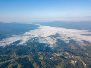 High flight in the mountains of the Ukrainian Carpathians. Fog in the valley. Aerial drone view.