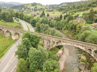 Fototapeta premium Old railway bridge in the mountains. Ukrainian Carpathians. Aerial drone view.