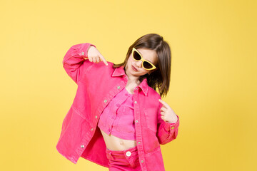 Arrogant little girl pointing herself isolated on yellow background. Egocentric child concept