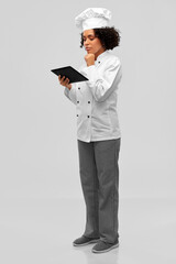 cooking, culinary and people concept - thinking female chef in toque and jacket with tablet pc computer over grey background