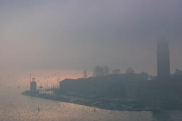 Fototapeta premium Winter foggy urban scene with people walking at coastal street in venice city, Italy