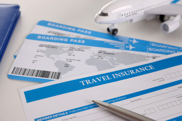 Airplane tickets, empty travel insurance form with pen, fill in information