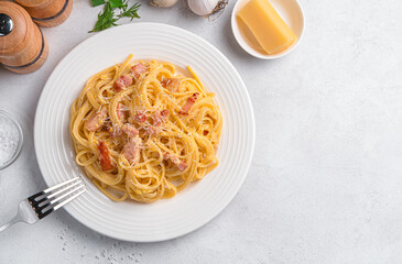Delicious pasta carbonara with bacon, parmesan, egg, cream and pepper on a gray background. Italian food.