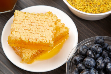 fresh assorted honey and blueberries on a wooden background. healthy organic vitamin food.