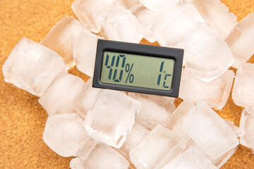 digital thermometer for measuring air temperature and humidity against the background of frozen ice
