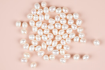 Natural freshwater pearls on a pink background, top view