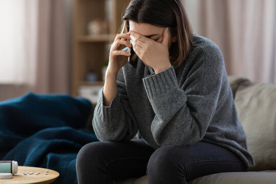 mental health, psychological help and depression concept - stressed woman with sedative medicine on table calling on phone at home