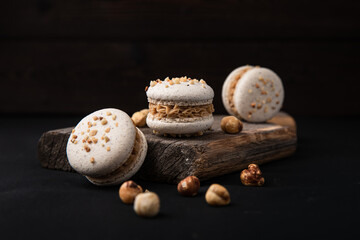 Macarons mit Heselnuss, schwarze Hintergrund, drei Stück.
