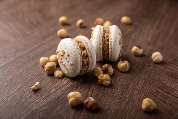 Macarons mit Heselnuss, Holz Hintergrund, zwei Stück.