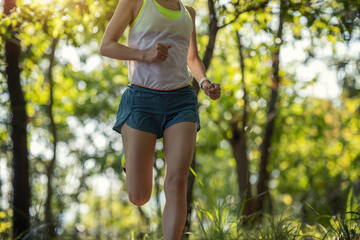 Woman runner running on forest trail
