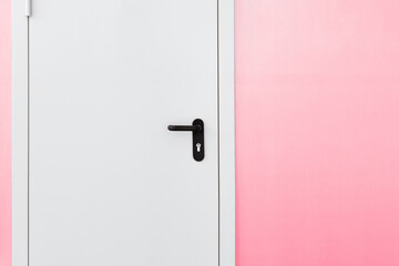 A closed white door in a pink wall