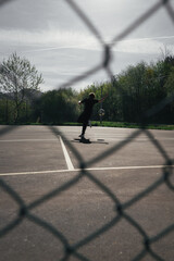BOY IN BLACK TRACKSUIT FREESTYLE WITH A BALL ON A FUTSAL FIELD