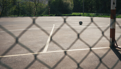 CLOSE-UP OF A NET, IN THE BACKGROUND A SOCCER BALL ON THE INDOOR SOCCER FIELD.