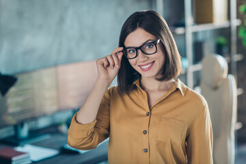 Photo of young cheerful pretty woman hand touch eyeglasses wear casual outfit agent designer jawa indoors - obrazy, fototapety, plakaty
