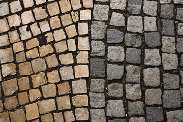 Mosaic of small marble cubes. sidewalks and squares formed by stone carpet with squares. Old cobblestones. High quality photo