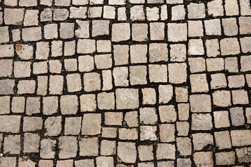 Naklejka premium Mosaic of small marble cubes. sidewalks and squares formed by stone carpet with squares. Old cobblestones. High quality photo