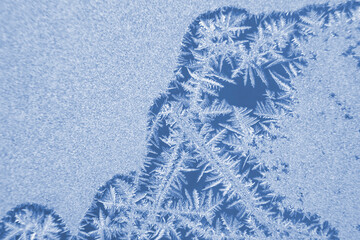 frosty patterns on the window glass closeup. natural textures and backgrounds. ice patterns on...