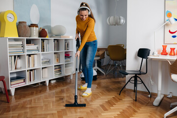 woman using vacuum cleaner at home