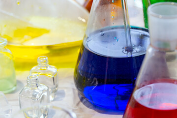 Beaker and and other laboratory items with green and blue chemical reagent. Chemical experiment...