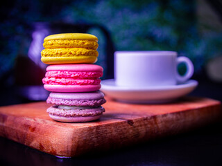 Hot tea with homemade macaroon cakes on a beautiful wooden dish.