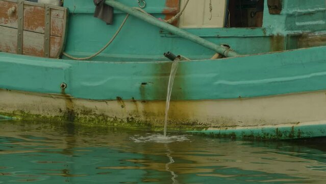 Fishing boat engine is cooling down by water pipe pump. Fishing Industry scene from Vietnam.